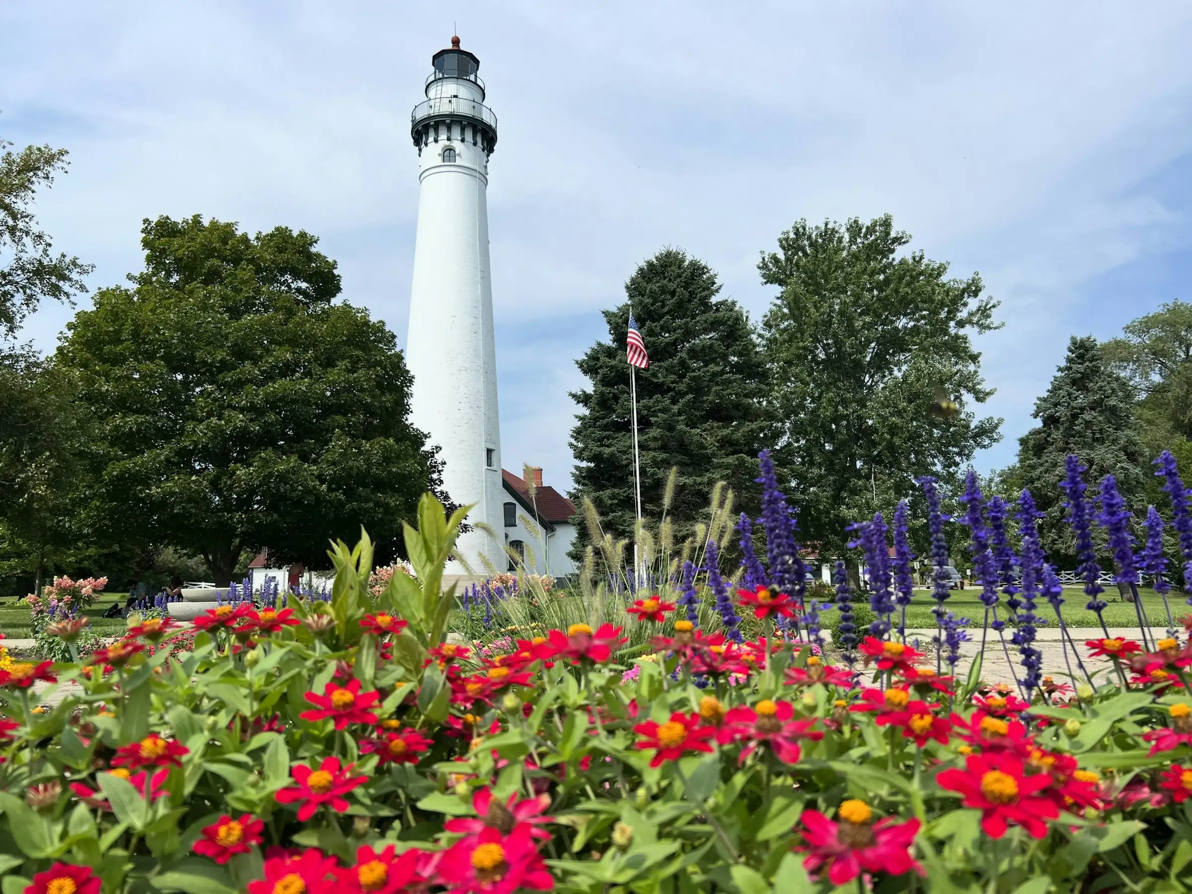 Wind Point Lighthouse above a bed of spring flowers on a sunny day, Lake Michigan